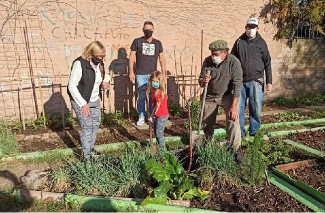 Voluntarios y una niña de 8 años ayudando en la huerta